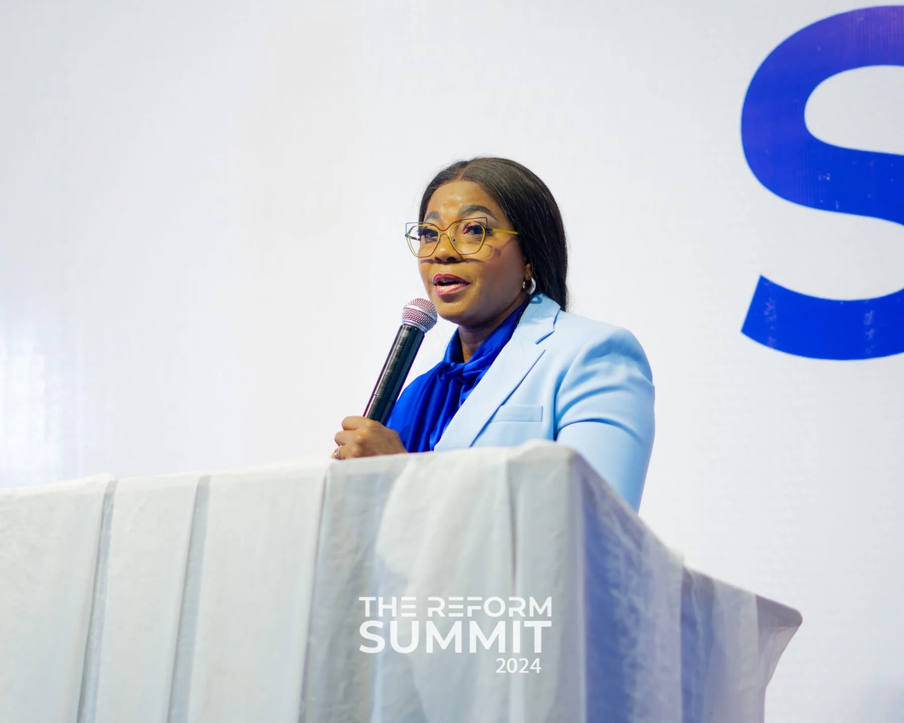 A business leader speaking on stage at The Reform Summit